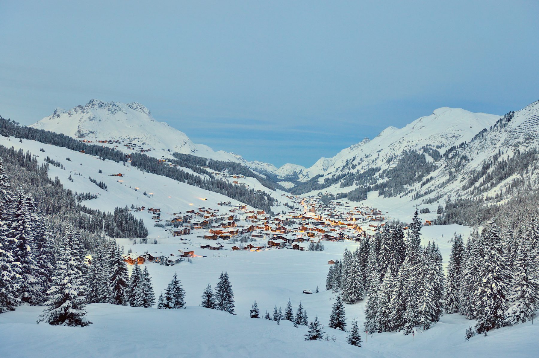 Esquiadores en Lech Zürs, Arlberg, con el pueblo nevado al fondo
